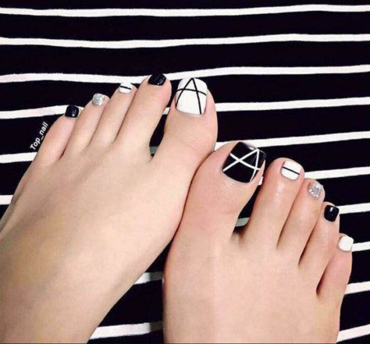 Pedicura en colores blanco y negro con detalles de líneas