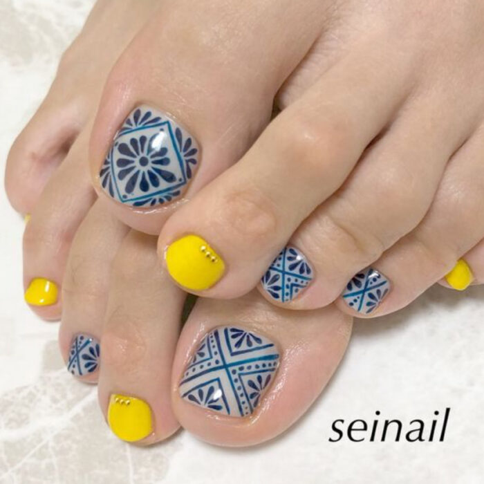 Pedicura en colores amarillo y azul con diseño de mosaico