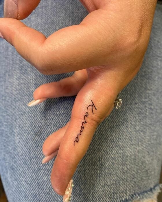 Tatuaje de palabra "karma" en el dedo