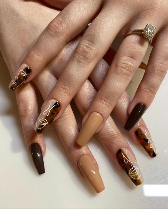 Manicura con diseño de rostros y tonos tierra