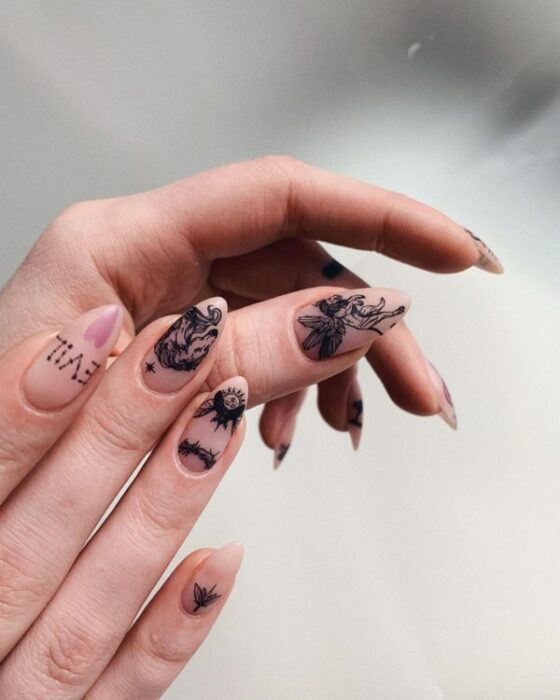 chica con manicura en color claro con estampados inspirados en demonios;  Uñas para chicas que aman el ocultismo