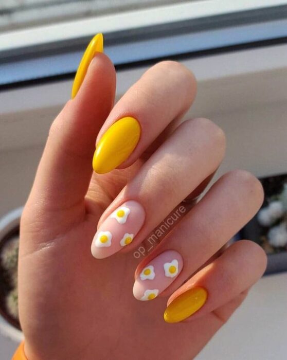 Chica con manicura stiletto en color amarillo con efecto mate