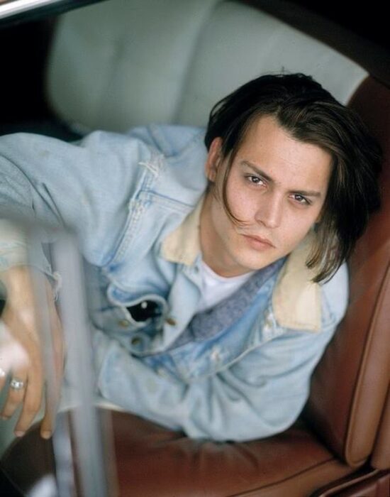 Johnny Depp posando para una fotografía dentro de un auto