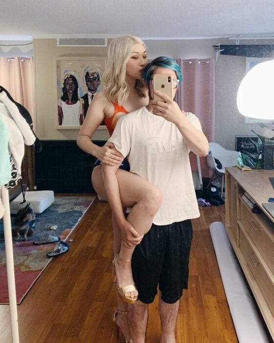 Chica alta y blanca posando junto a su novio en una selfie frente al espejo 