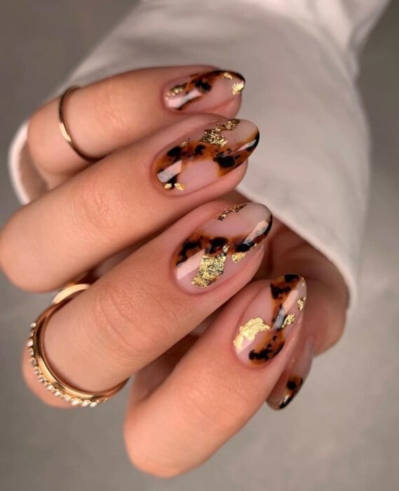 Uñas elegantes ovaladas con toque dorado y de animal print