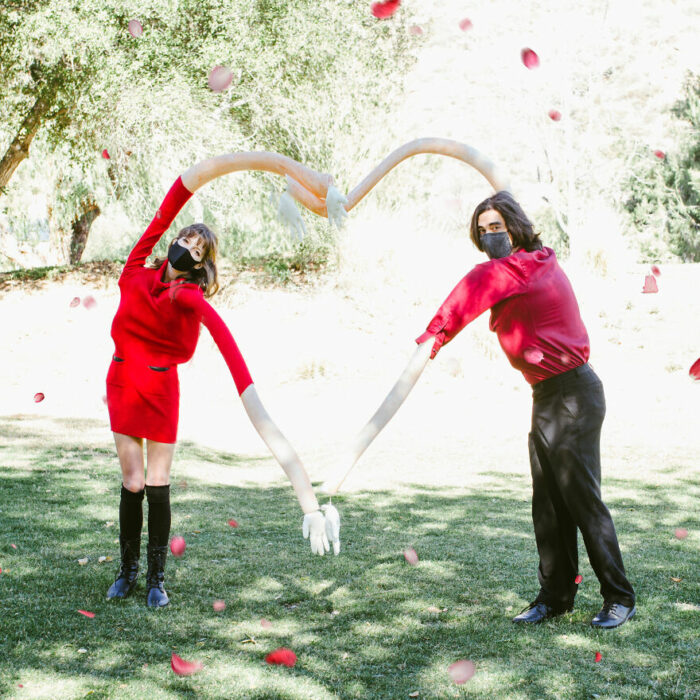 Pareja formando un corazón con brazos gigantes; fotografía de Alexa Machado