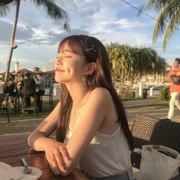 Chica asiática tomando el sol y sonriendo
