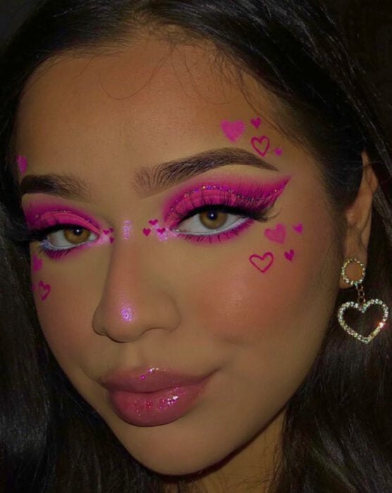 Maquillaje inspirado en San Valentín en colores rosa fosforescentes y delineado negro 