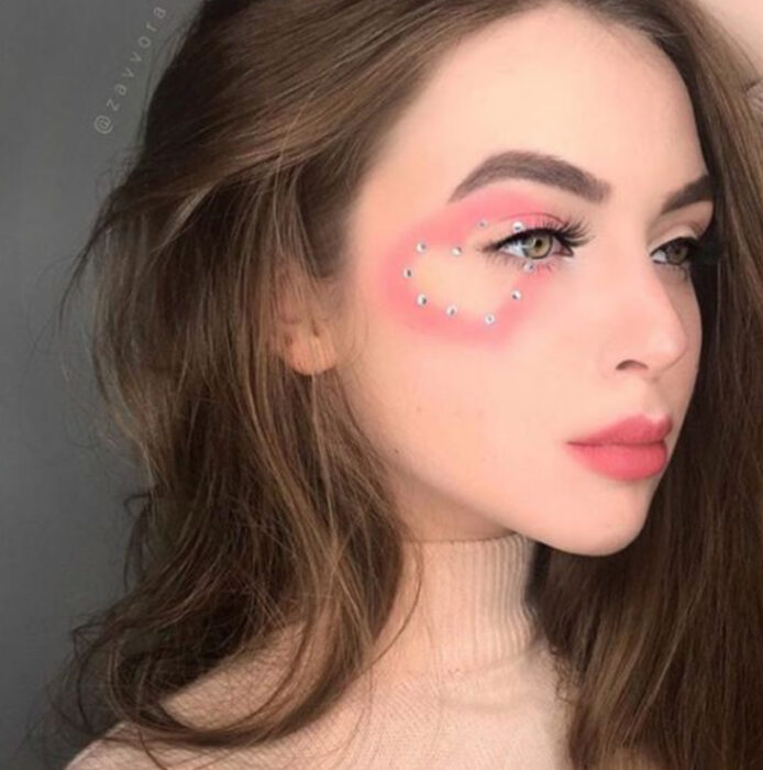 Maquillaje inspirado en San Valentín en colores rosa bebé con silueta de corazón y aplicaciones de perlas