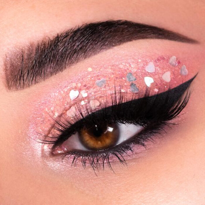 Maquillaje inspirado en San Valentín en colores rosa y aplicaciones de glitter