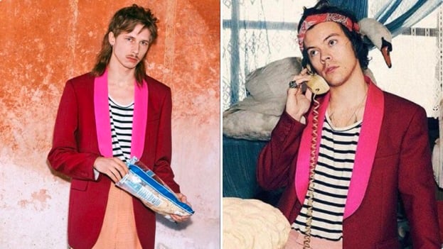 Harry Styles vistiendo  un saco rojo con rosa con una playera blanca con rayas negras con un paliacate rojo en la cabeza y sosteniendo un teléfono con la mano derecha 