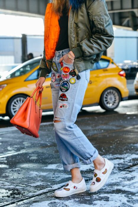 chica llevando jeans rotos con parches decorativos; ; 13 Maneras de salvar tus jeans rotos y seguir a la moda 