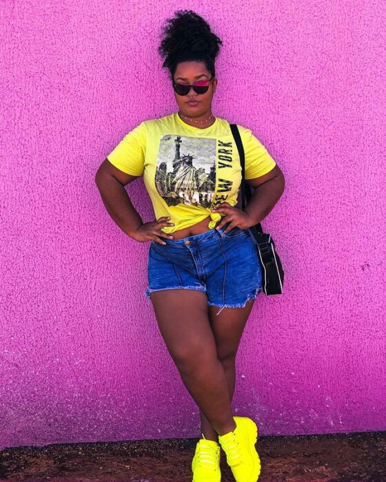 Chica con short de mezclilla y top amarillo neón; 13 Outfits con tenis neón para deslumbrar a cada paso 