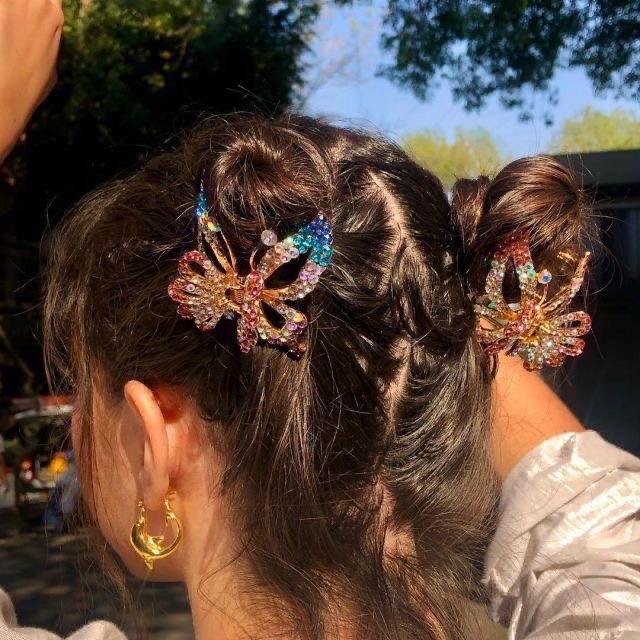 Chica con doble bun alto y broches de mariposa; 13 Peinados lindos para compartir en tus stories de Instagram