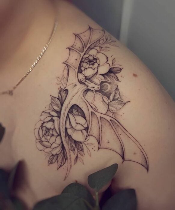 Tatuaje de dragón sobre un hombre lleno de flores; 13 Tatuajes para convertirte en la nueva Daenerys Targaryen, madre de dragones