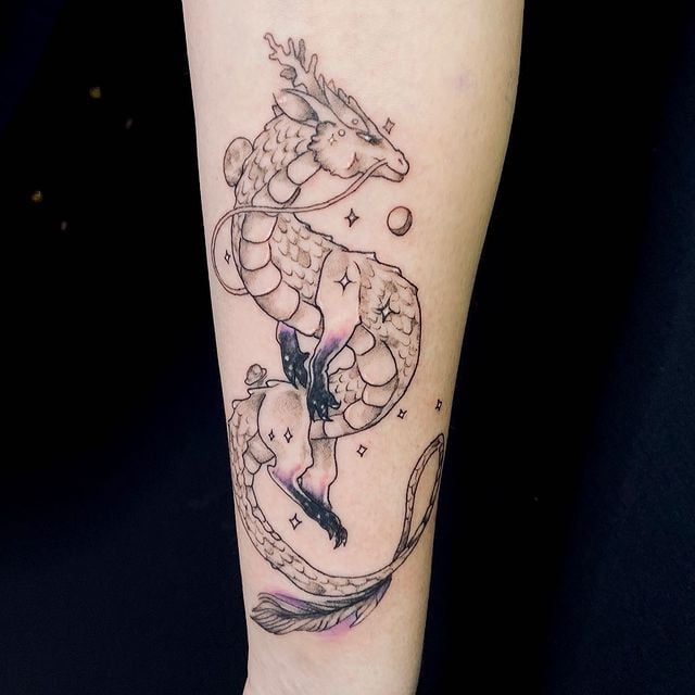 Tatuaje de dragón en estilo chibo en tonos negro y morado; 13 Tatuajes para convertirte en la nueva Daenerys Targaryen, madre de dragones