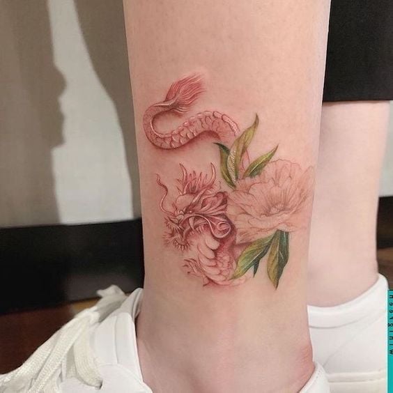 Tatuaje en tonos rosas con flores a un costado; 13 Tatuajes para convertirte en la nueva Daenerys Targaryen, madre de dragones