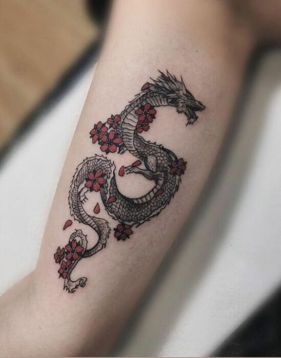 Tatuaje de dragón en tono negro con flores rojas; 13 Tatuajes para convertirte en la nueva Daenerys Targaryen, madre de dragones