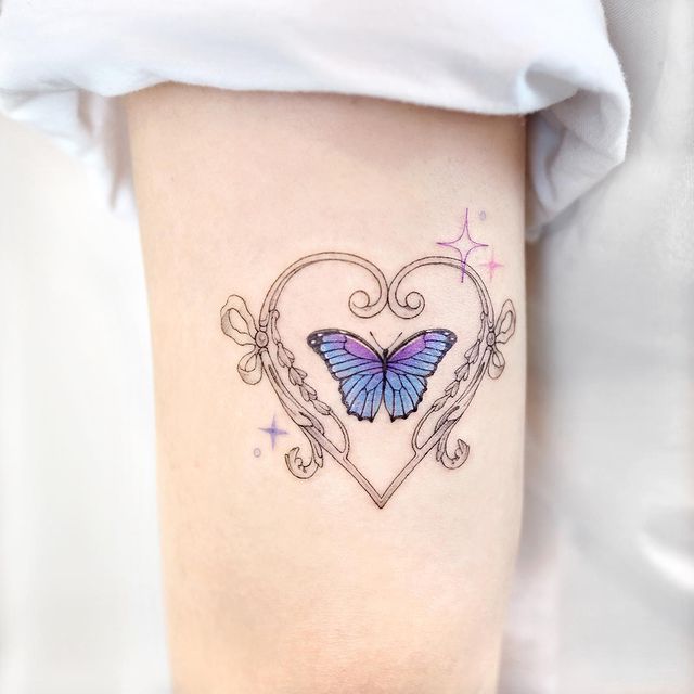 Tatuaje de mariposa en tonos morados rodeado por un corazón;  15 Bellos tatuajes con mariposas para iniciar una metamorfosis