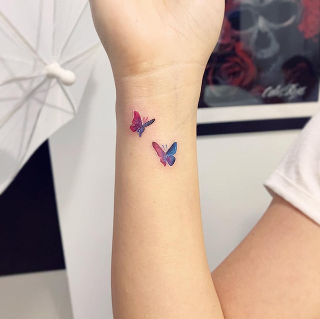 Chica con tatuajes de mariposas en colores rosa y azul; 15 Bellos tatuajes con mariposas para iniciar una metamorfosis