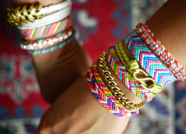 Chica usando unas pulseras tejidas de diferentes colores 