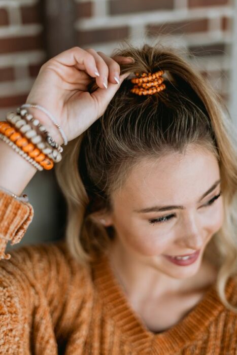 Chica usando unas ligas en el cabello 