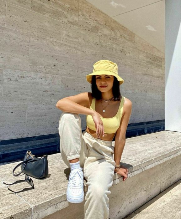 Chica usando un bucket hat con su outfit de color amarillo 