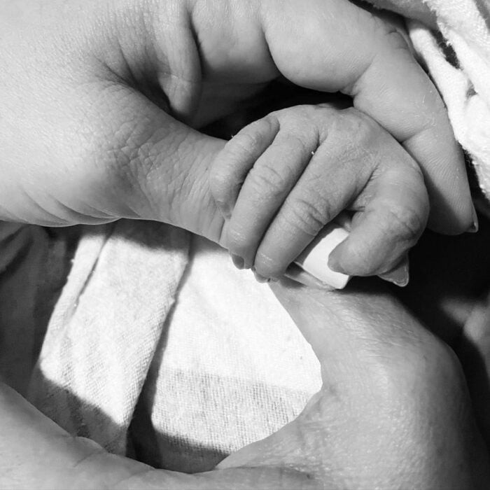 Ashley Tisdale sosteniendo la mano de su bebé recién nacida 