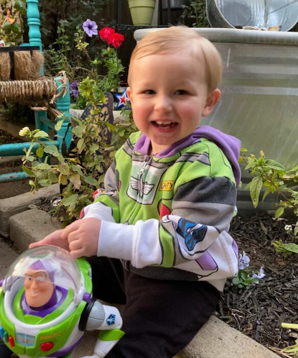 Niño sonriendo al tener de vuelta a su muñeco Buzz Lightyear; Buzz Lightyear regresa con su pequeño amigo fiel después de extraviarse en un avión