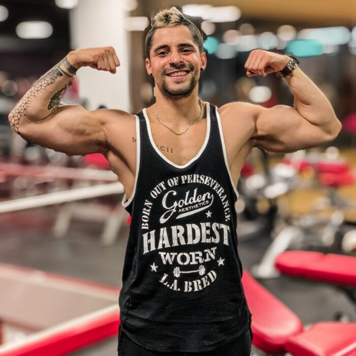 Chico posando para una fotografía mientras está en el gimnasio 