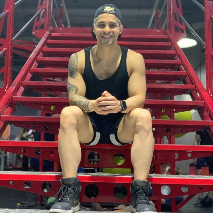 Chico posando para una fotografía mientras está en el gimnasio 