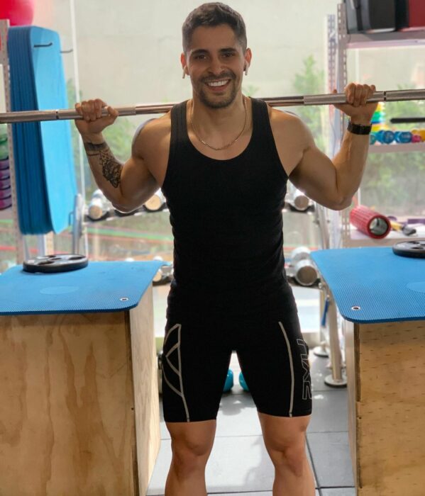 Chico haciendo ejercicio con una barra de pesas en el gimnasio 