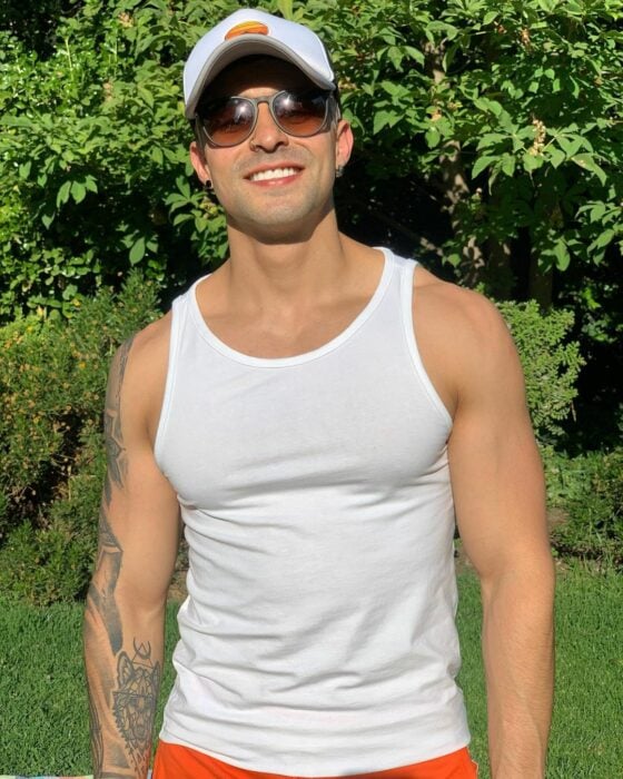 Chico usando una camisa de mangas mientras toma el sol en el jardín 
