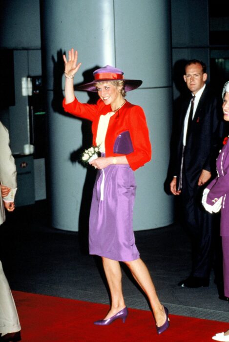 Ladi Di usando un outfit en colores rojos y morados con unos zapatos de color purpura 