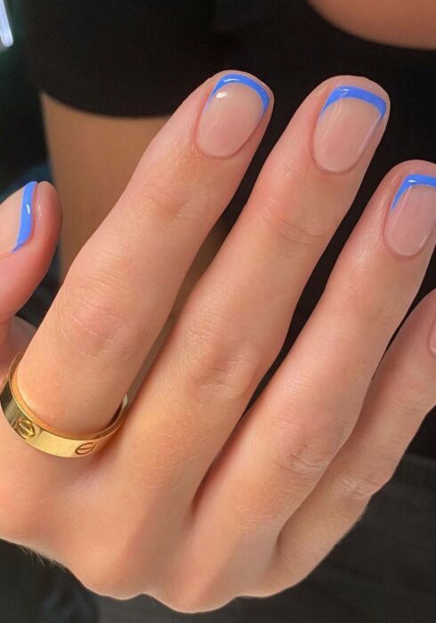 Diseño de uñas en tono nude con un color en azul en la punta 