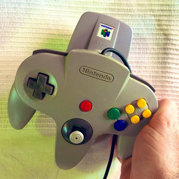 Control de nintendo 64 de color gris con botones de diferentes colores 