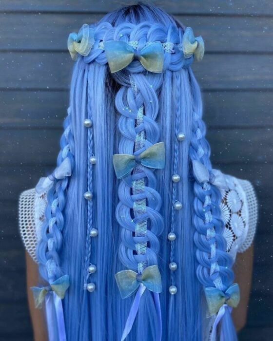 Chica con el cabello teñido de color azul y trenzado y decorado de diferente manera 