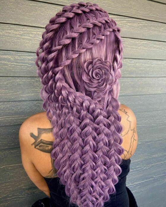 Chica con el cabello teñido de color morado y trenzado de diferentes maneras