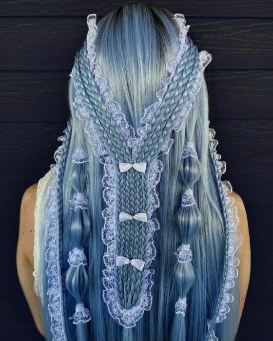 Chica con el cabello teñido de color azul y trenzado de diferentes maneras 