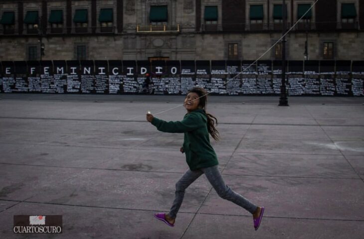 Niña corriendo con un papalote feliz 