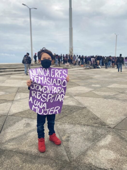 Niño sosteniendo una pancarta durante las marchas del 8 de marzo