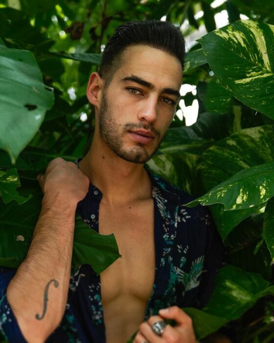 Michel Duval posando para una sesión de fotos mientras está escondido entre las plantas 