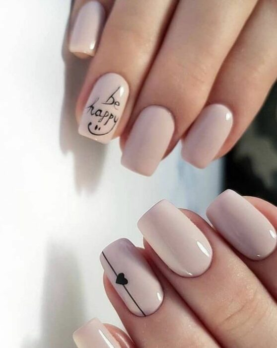 Manicura en tono nude con estampado de corazón en tono negro; Ideas para manicura nude