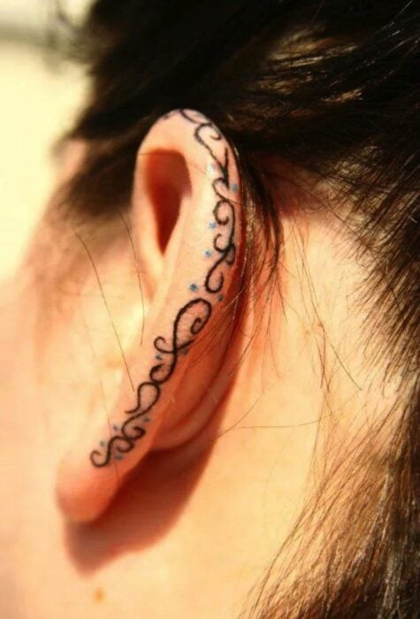 Chica con un tatuaje en la oreja en forma de espinas
