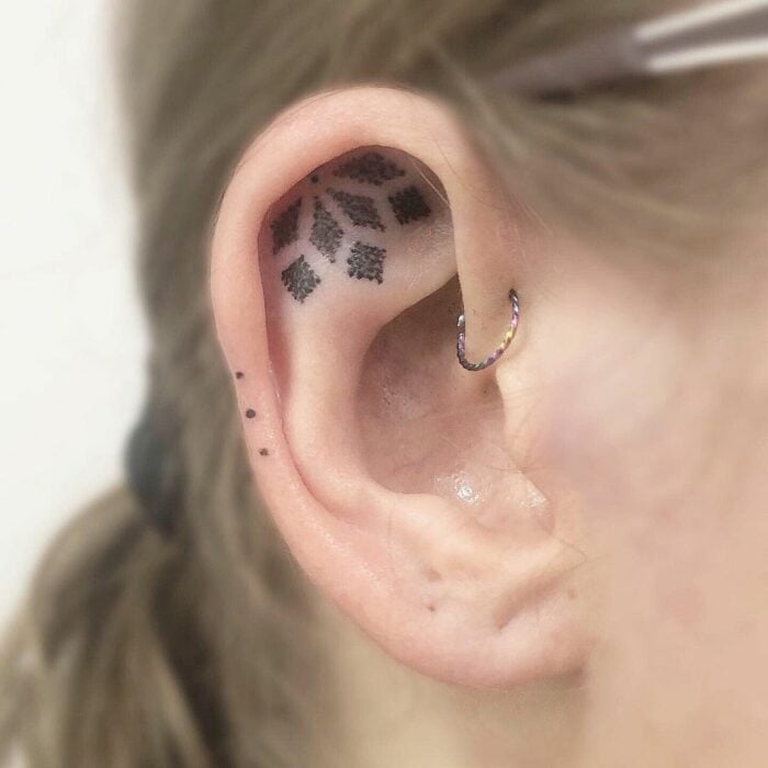 Chica con un tatuaje en la oreja en forma de mandala