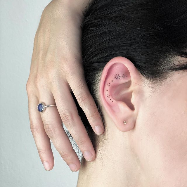 Chica con un tatuaje en la oreja en forma de puntos que forman una flor