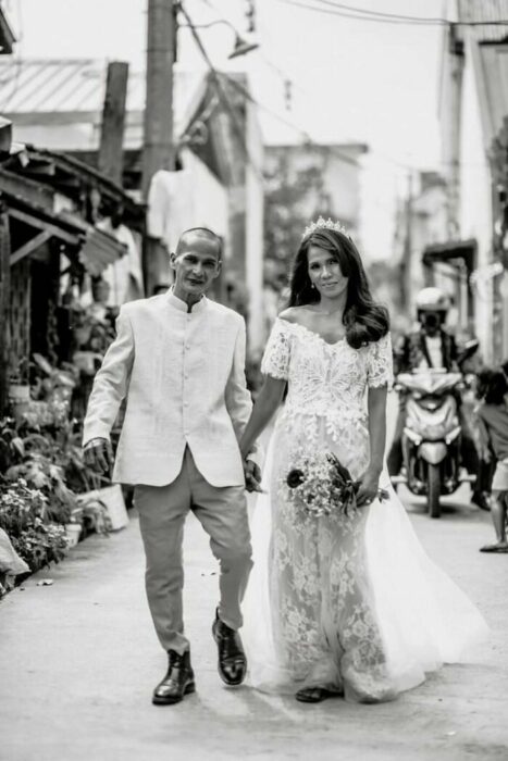 Pareja vestidos de novios posando para una foto el día de su boda 