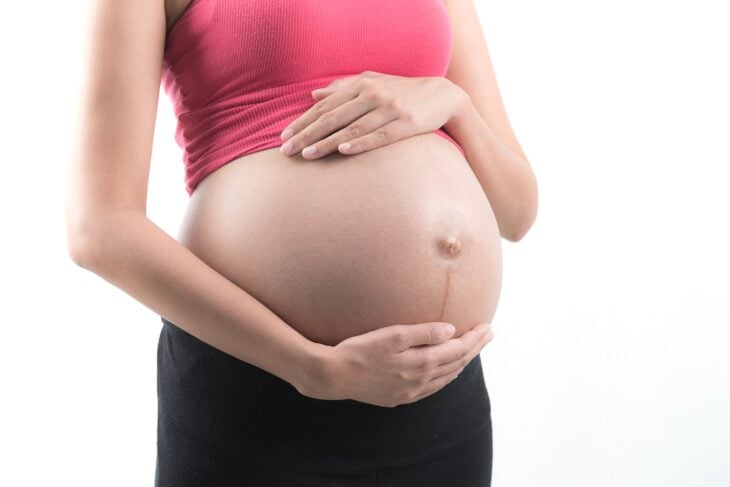 Mujer embarazada mostrando su vientre con línea alba