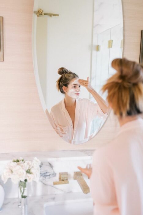 Chica frente al espejo aplicándose una mascarilla; Mascarillas con huevo para una piel bonita