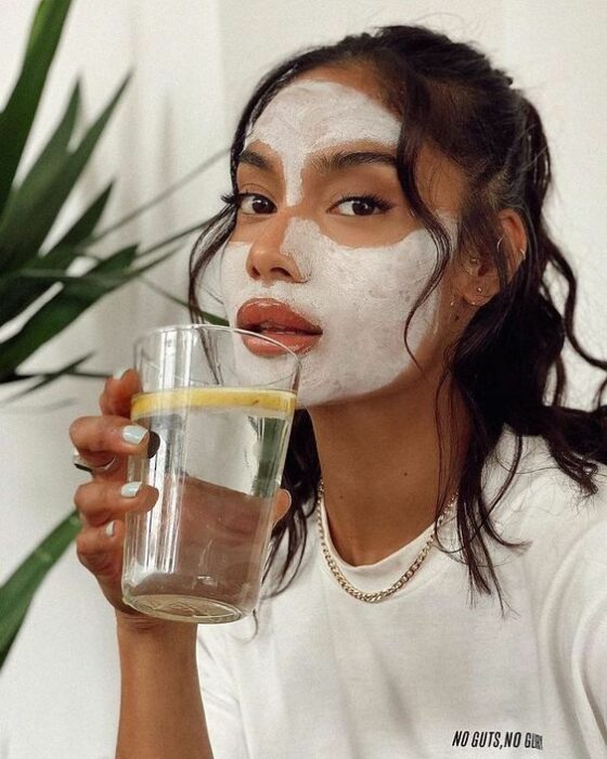 Chica llevando mascarilla y bebiendo agua; Mascarillas con huevo para una piel bonita